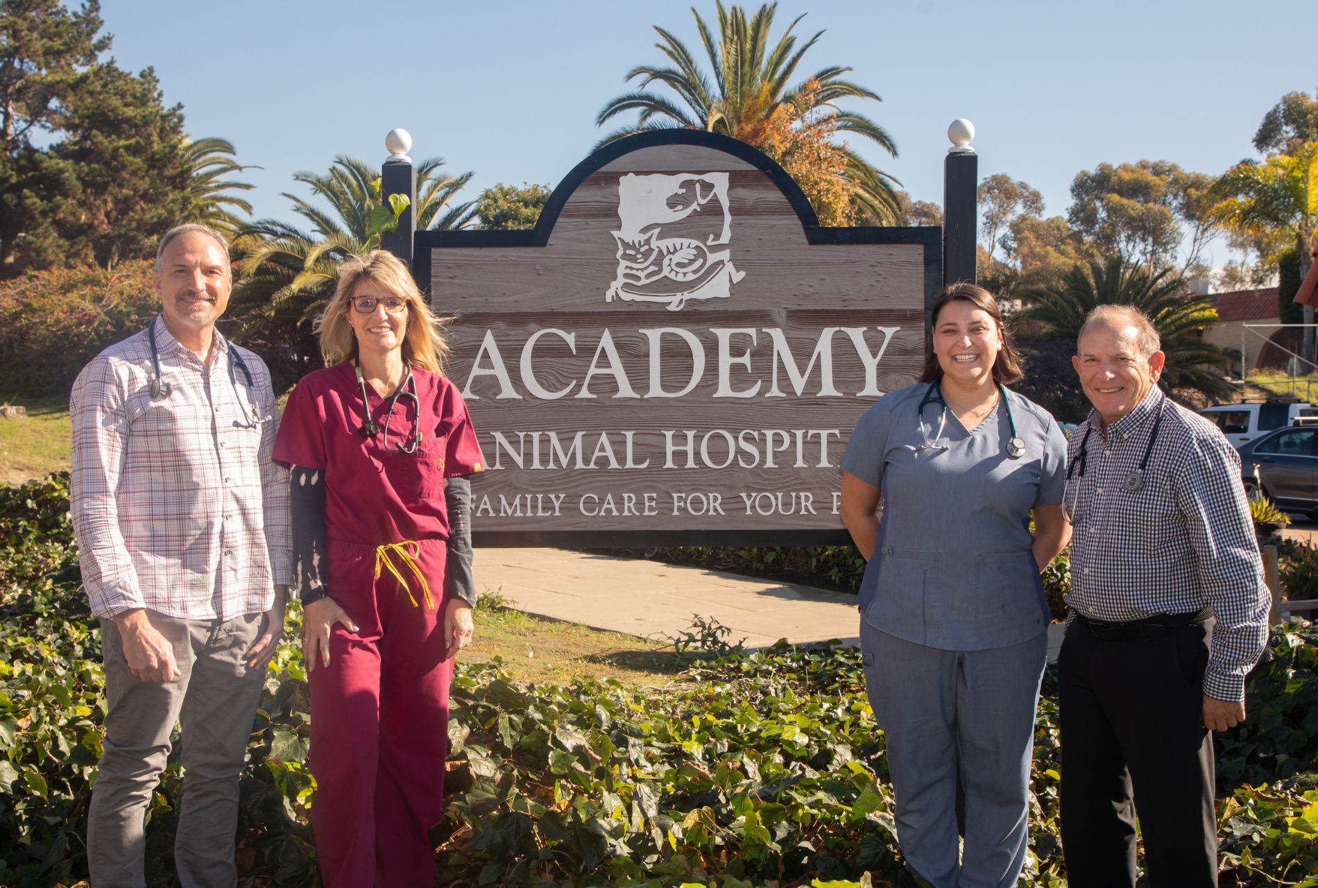 Group of veterinary professionals standing in front of sign outdoors
