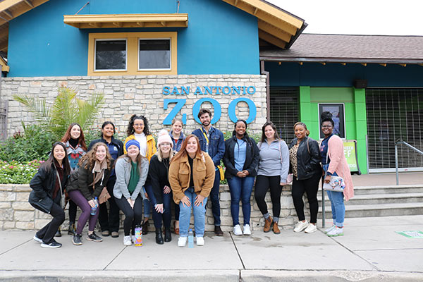 group posing in front of San Antonio Zoo