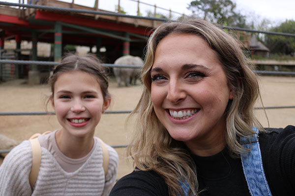 young women smiling at camera outdoors